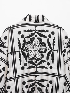 Gros plan du grand motif floral et géométrique au dos de la chemise imprimée blanche