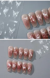 Macro view of 5D embossed white butterfly nail stickers with delicate pearl accents