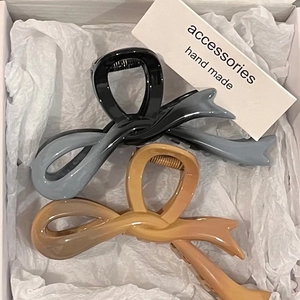 Elegant gradient acrylic bow claw clips in black and beige displayed in an aesthetic gift box
