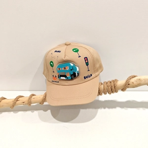 Dettaglio cappello bambino kaki con ricamo di camion blu e segnali stradali colorati