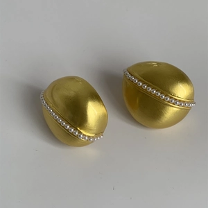 Dettagli di orecchini vintage dorati satinati a goccia con inserti di perle bianche