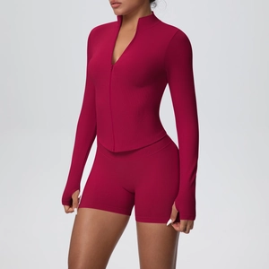 Gros plan détaillé sur la veste de yoga rouge baie avec col montant et passe-pouces