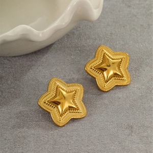 Macro detail of gold-plated star stud earrings featuring a beaded relief texture