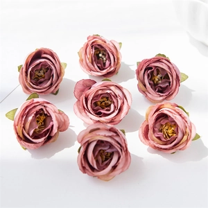 Close-up of seven vintage pink silk artificial rose heads for DIY floral crafts