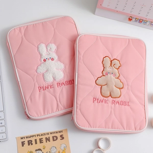 Quilted pink laptop sleeve featuring an embroidered rabbit and soft cotton texture