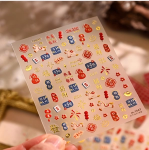 Macro detail of 3D New Year nail stickers with Lucky Cat and gold lantern designs