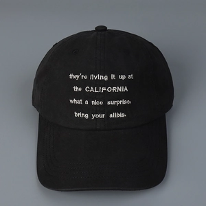 Close-up of white letter embroidery on a black washed cotton baseball cap fabric
