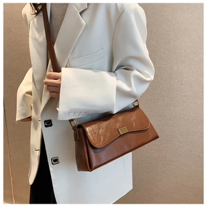 Nahaufnahme der braunen Leder-Achseltasche mit Metallschnalle und verstellbarem Gurt