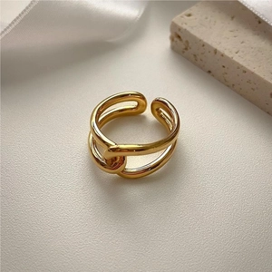 Minimalist double layer golden criss-cross adjustable ring on elegant textured background