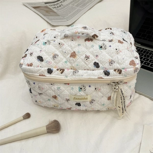 Detail of quilted cotton makeup bag with cute dog prints and dual-zipper closure