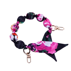 Detail of pink and black floral silk scarf chain strap with golden metal spring clasps