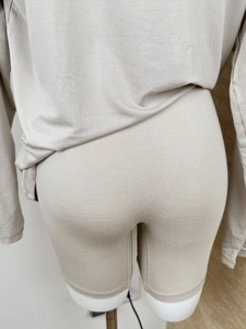 Detail view of beige high-stretch long sleeve top and matching shorts from the back
