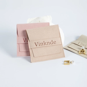 Détails des pochettes à bijoux en suédine beige, rose et gris clair avec coquillage et boucles