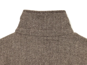 Detail shot of the stand collar back showing brown herringbone tweed wool fabric texture