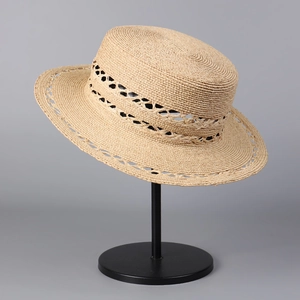 Detailed macro view of the intricate hollow weave patterns on a summer boater straw hat