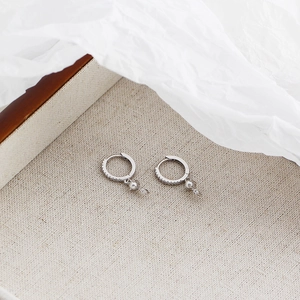 Detail of silver S925 earrings with sparkling crystals and elegant pearl pendants