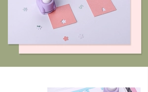 Close-up of a purple flower puncher creating petal shapes on pink craft paper
