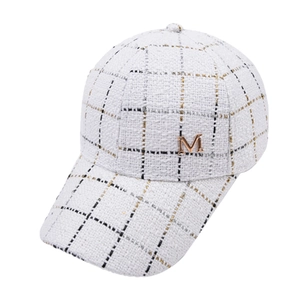 Close-up of white tweed baseball cap with plaid pattern and metallic M logo detail