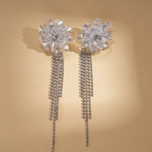 Macro detail of crystal flower earrings featuring long dangling rhinestone fringe tassels