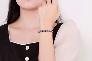 Detail of blue stone beaded bracelet with silver spacers worn on a female wrist