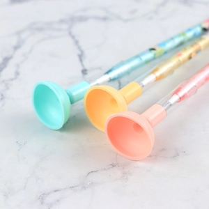 Macro detail of plunger-shaped pens in pastel green, yellow, and pink colors
