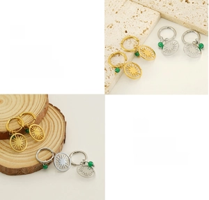 Detail of sunburst drop earrings with green bead accent on stone and wood texture