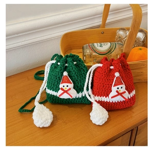 Detail view of handmade Christmas crochet drawstring pouches with 3D snowman and woven texture