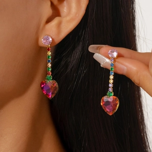 Macro detail of luxury colorful zircon heart earrings with long sparkling tassel fringe