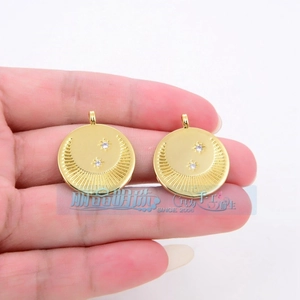 Detail of round golden flower charms with embossed texture and sparkling star-set crystals