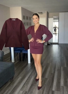 Détail d'un ensemble en maille bordeaux avec cardigan à col en V et mini-jupe