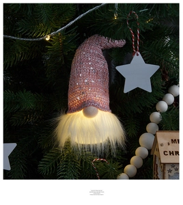 Glow-in-the-dark pink sequin gnome ornament hanging on a Christmas tree branch