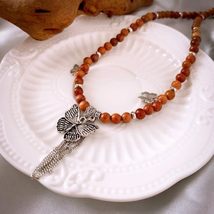 Collier vintage en perles de bois de santal avec pendentif papillon et franges métalliques
