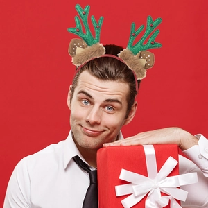 Close-up of a festive Christmas headband with green glitter antlers and brown plush ears