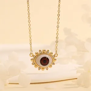 Detail of 18K gold plated Evil Eye necklace with reddish-brown eye and sparkling zircons