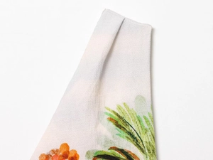 Close-up of creped fabric texture with orange flowers and green leaves pattern