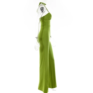 Side view of a green halter neck jumpsuit with pleated bodice and wide leg drape