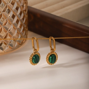 Macro view of gold twist oval earrings with green malachite inlay in vintage style