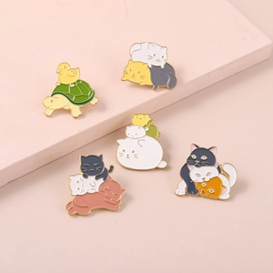 Close-up of colorful enamel cat and duck pins on a soft pink minimalist display