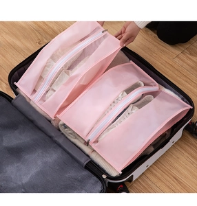 Detail of pink mesh travel storage bags with zippers organized inside a black suitcase