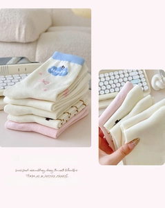 Detail of soft cotton crew socks featuring cute cloud patterns and blue contrast cuffs
