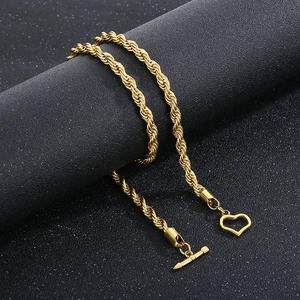 Detail of a golden twisted rope chain necklace with heart pendant and T-bar OT toggle clasp