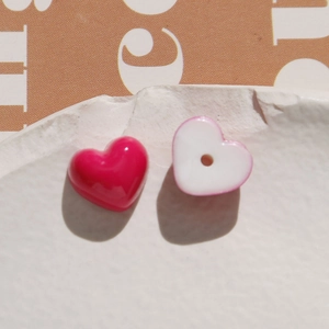 Macro detail of heart-shaped resin beads with magenta and white finish for DIY jewelry