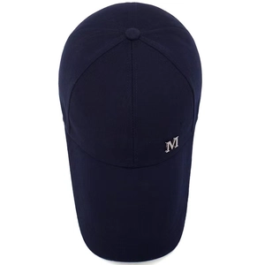 Gros plan détaillé de la casquette de baseball en toile bleu foncé avec logo M en métal