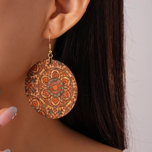 Close-up of Bohemian round leather earrings with colorful mandala pattern on a model