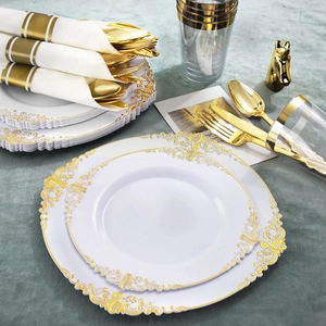 Detail of luxury white disposable plates with gold baroque relief and golden cutlery
