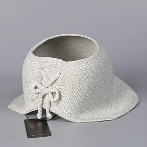 Detail view of light grey knitted open top sun hat with bow decoration and hangtag