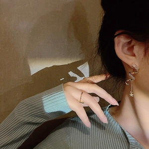 Gros plan de boucles d'oreilles serpent dorées avec étoiles et diamants sur le modèle