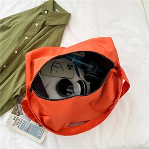 Large orange oxford fabric fitness bag shown with personal items for travel packing