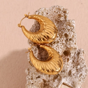 Macro shot of 18K gold plated hollow oval earrings featuring thick textured ribbing details