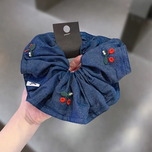Denim scrunchie with cherry embroidery and pearl accents for elegant hair styling